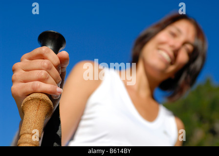 Jeune femme en randonnée dans les montagnes boisées tenant un pôle trekking, vallée du Stubaital, Tyrol, Autriche, Europe Banque D'Images