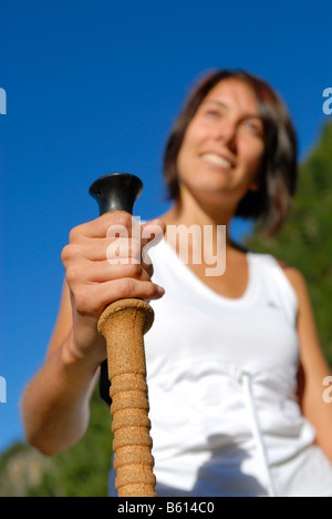 Jeune femme en randonnée dans les montagnes boisées tenant un pôle trekking, vallée du Stubaital, Tyrol, Autriche, Europe Banque D'Images