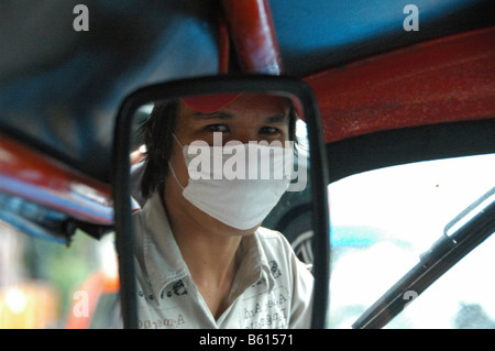 Un pilote Tuk-Tuk, portant un masque de visage à cause de la mauvaise qualité de l'air, Bangkok, Thailande, Asie Banque D'Images