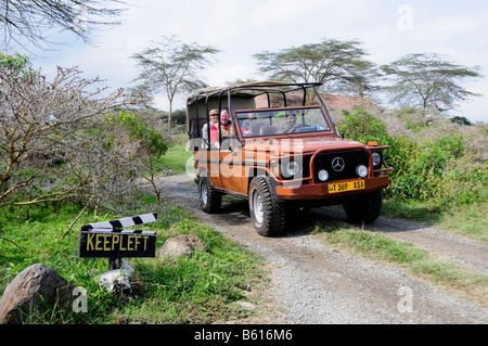 Les touristes dans un véhicule à quatre roues motrices, safari à Hatari Lodge, ancienne ferme de Momella Hardy Krueger sen., Parc National d'Arusha. Banque D'Images