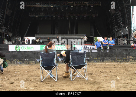 Festival de Glastonbury fans arriver tôt assis en attendant le début de la journée sur une scène vide Juin 2008 Banque D'Images