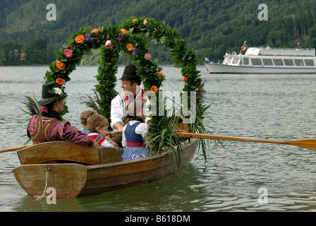 Bateau décoré de fête avec une famille portant des costumes traditionnels à l'Alt-Schliersee churchday, lac Schliersee Banque D'Images