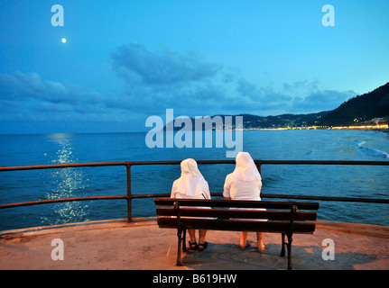 Deux religieuses assis sur un banc, profitant de la vue sur la mer sur la côte d'Alassio, Riviera dei Fiori, Ligurie, Italie, Europe Banque D'Images