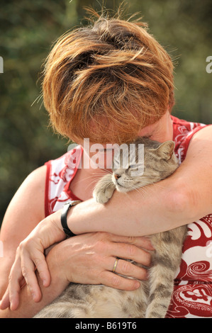 Jeune chat tigré gris smooching avec une femme Banque D'Images