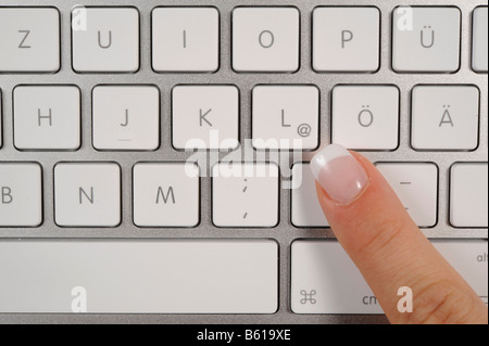 Clavier d'un ordinateur portable MacBook Pro Apple, doigt pointant vers le symbole @ Banque D'Images