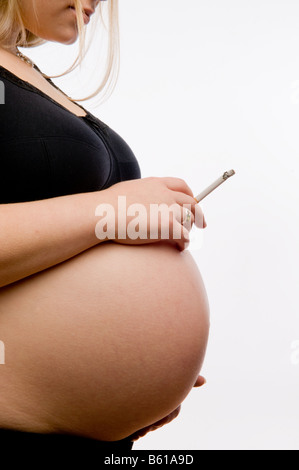 8 1/2 mois de grossesse femme fille de fumer la cigarette, contre tous les bons conseils médicaux pour les mères d'être Banque D'Images