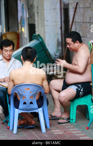 Les hommes chinois bénéficiant d'un jeu de carte dans la ruelle Banque D'Images