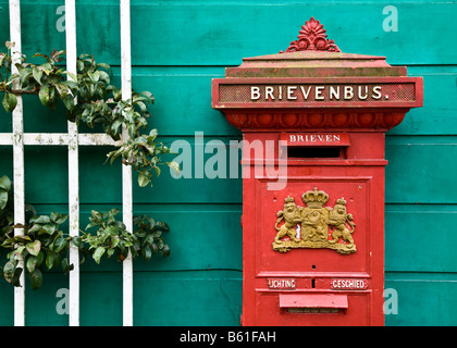 Un vieux rouge, antique Dutch postbox a le mur d'une maison verte, Arnhem, Pays-Bas Banque D'Images