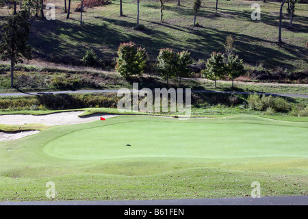 Un vert avec un drapeau rouge marquant le trou sur un terrain de golf pendant la saison d'automne à Branson Missouri Banque D'Images