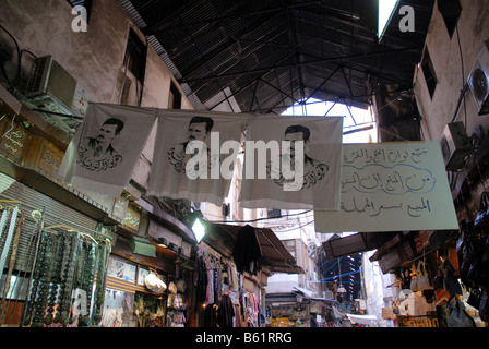 Drapeaux avec portrait du président Baschar-al-Assad dans le souk dans le centre historique de la ville de Damas, en Syrie, au Moyen-Orient, en Asie Banque D'Images