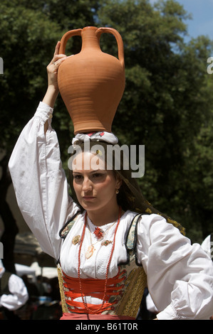 Jeune femme portant le costume traditionnel portant une amphore sur la tête à Cavalcata Sarda Festival à Sassari, Sardaigne, Italie Banque D'Images