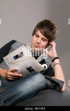 Jeune homme lisant sur un bean bag Banque D'Images