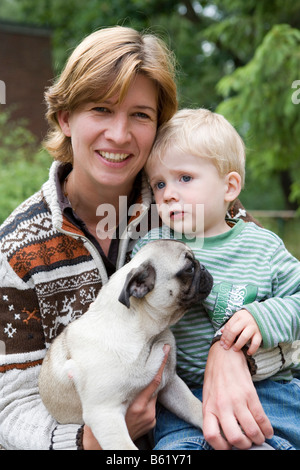 Jeune femme, 30 +, enfant, garçon, 2, chien, chiot, pug, portrait Banque D'Images