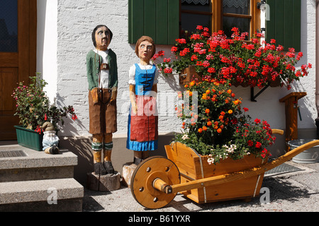 Figures en bois d'un couple, Barrow en bois en face d'une ferme à Stoetten suis Auerberg, vue de l'intérieur, l'Allgaeu Bayerisch souabe, Bava, Banque D'Images