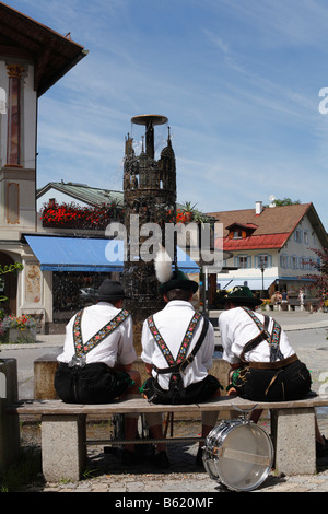 Trois jeunes hommes portant des Lederhosen traditionnelles en face de la fontaine sur Dorfstrasse, Oberammergau, Allemagne, E Banque D'Images