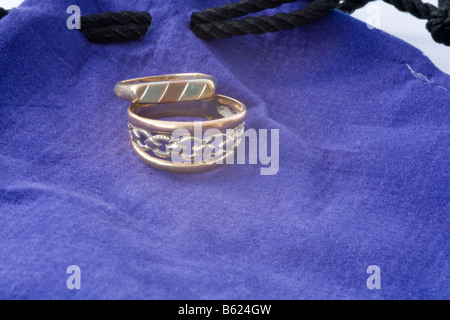 Close up Studio deux anneaux d'or, couché sur une pochette bijoux violet Banque D'Images