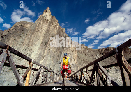 Mountainbiker traversant un pont de bois, Gilgit, Karakorum Highway, Northern Areas, Pakistan, Asie Banque D'Images
