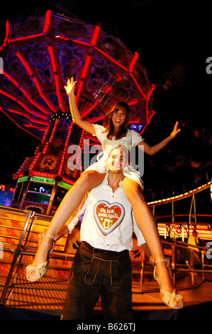 Couple en face d'un carrousel à chaîne, Wies'n, l'Oktoberfest, Munich, Bavaria, Germany, Europe Banque D'Images