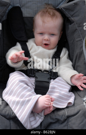 Bébé garçon attaché dans une poussette Banque D'Images