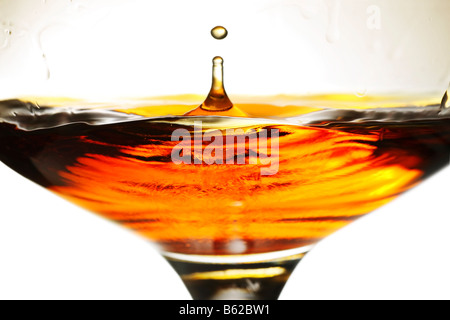 Dans un petit verre de brandy verre splash Banque D'Images