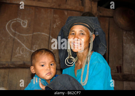 Femme de la tribu Akha Phixo avec coiffe traditionnelle et de l'enfant, l'interdiction des Mososane Phongsali, Province, Laos, Asie du sud-est Banque D'Images