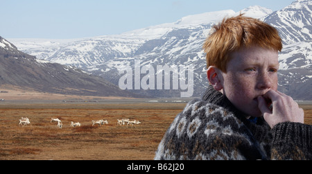 Portrait of red headed boy avec l'élevage du renne en arrière-plan, l'Islande de l'Est du fjord Hornafjordur Banque D'Images