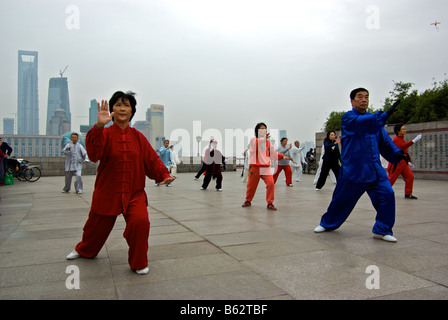 Les praticiens du Tai Chi comme ils pratiquent leurs arts martiaux rituelle au Bund tôt le matin Banque D'Images