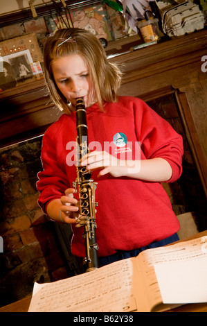 Un jeune 10 ans fille de l'école primaire la pratique de clarinette à home UK Banque D'Images