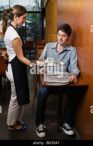 Serveuse qui sert du café à un client Banque D'Images