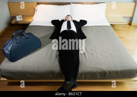 Businessman sieste sur le lit Banque D'Images