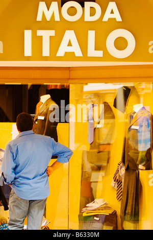 L'homme à la fenêtre à l'affichage à un magasin de vêtements, Gênes, ligurie, italie Banque D'Images