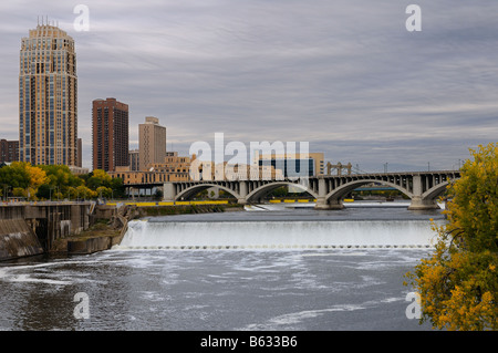 St Anthony Falls sur la rivière Mississippi à Minneapolis avec le Carlyle highrise et Troisième avenue bridge avec les nuages de tempête Banque D'Images