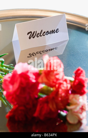 Close-up de fleurs avec un mot de bienvenue dans une assiette Banque D'Images