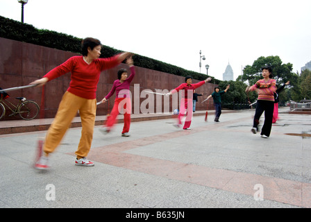 Des praticiennes du Tai Chi dans le motion blur comme ils pratiquent leurs arts martiaux rituelle au Bund tôt le matin Banque D'Images