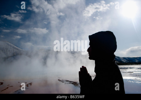 Silhouette d'un homme dans une position de prière à proximité d'une source chaude, Grand Prismatic Spring, Yellowstone National Park, Wyoming, USA Banque D'Images