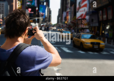 Vue arrière d'un touriste photographiant, Times Square, Manhattan, New York City, New York State, USA Banque D'Images