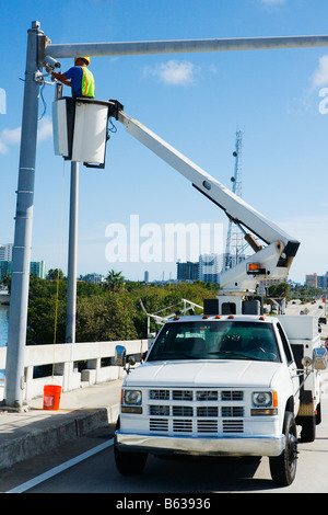 Portrait d'un ingénieur de maintenance sur une grue mobile réparation d'une caméra de sécurité sur un poteau Banque D'Images