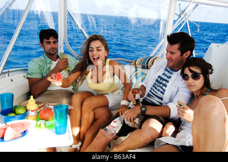 Deux couples enjoying beer et de fruits dans un tourboat Banque D'Images