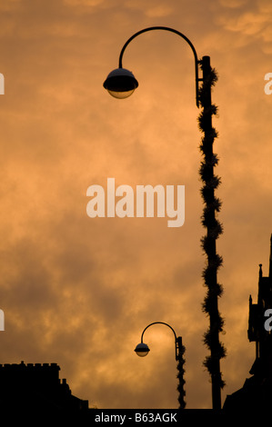 Lumière rougeoyante sur underlit Mammatus nuages à coucher du Soleil, Moody oppressive sentiment étrange, lampadaire en silhouette, UK Banque D'Images