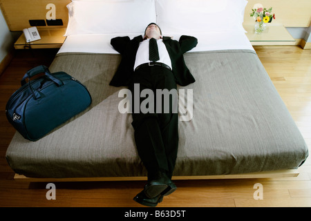 Businessman sieste sur le lit Banque D'Images