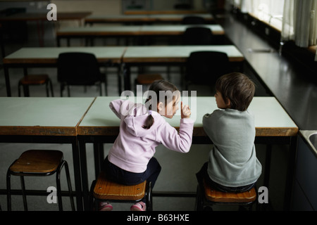 Petite fille de cinq ans et de six ans s'asseoir seul dans un laboratoire scientifique de l'école Banque D'Images