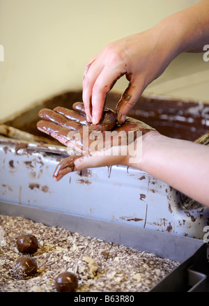 Les truffes étant roulé à la main avant de plonger dans les copeaux de chocolat. Photo par Jim Holden. Banque D'Images