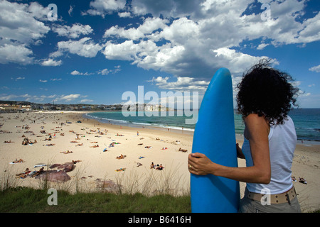 L'Australie, Sydney, Bondi Beach. woman holding surfboard Banque D'Images
