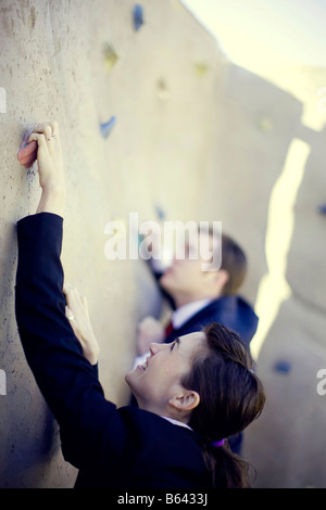 Businessman and businesswoman en montant vers le haut du mur Banque D'Images