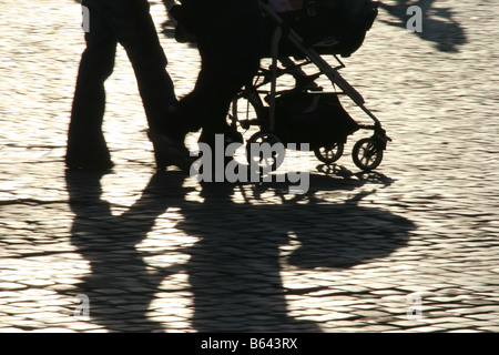 Les gens de l'ombre de vitesse rapide pieds jambes poussant dans la pram bébé soleil en rue en ville Banque D'Images