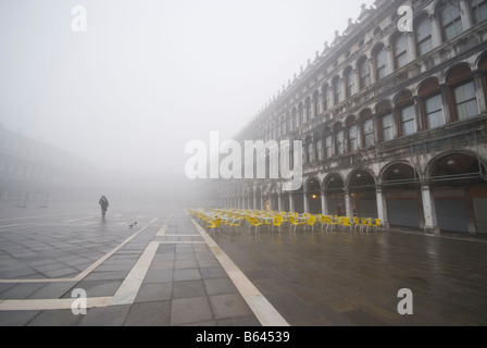 Femme seule prendre early misty promenade matinale sur la Piazza di San Marco à Venise, Italie Banque D'Images