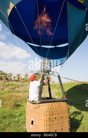 Torremolinos Costa del Sol Malaga Province Espagne Man filling hot air balloon à l'aide de brûleurs au propane la préparation pour le vol Banque D'Images