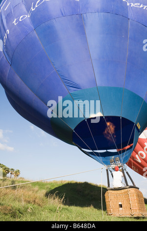 Torremolinos Costa del Sol Malaga Province Espagne Man filling hot air balloon à l'aide de brûleurs au propane la préparation pour le vol Banque D'Images