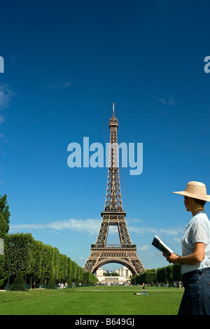 France, Paris, Tour Eiffel, Woman Reading guide book Banque D'Images