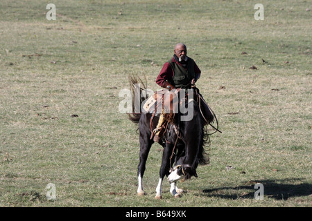 Un Africain American cowboy au Texas contre un tronçonnage bronco dehors sur la plage Banque D'Images